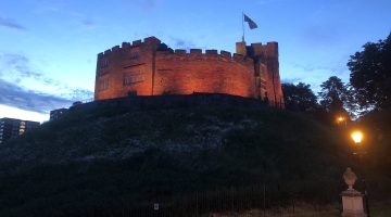 Tamworth Castle lit up yellow in the evening 