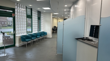 photo of inside reception with blue separating glass and chairs
